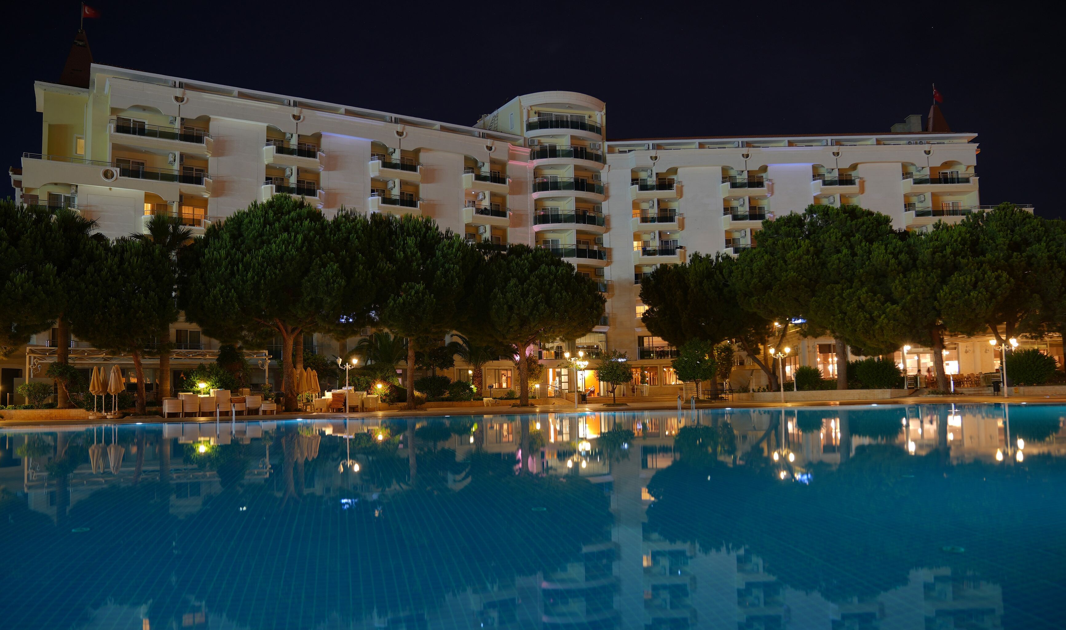 A multi-story hotel with a swimming pool in the foreground.