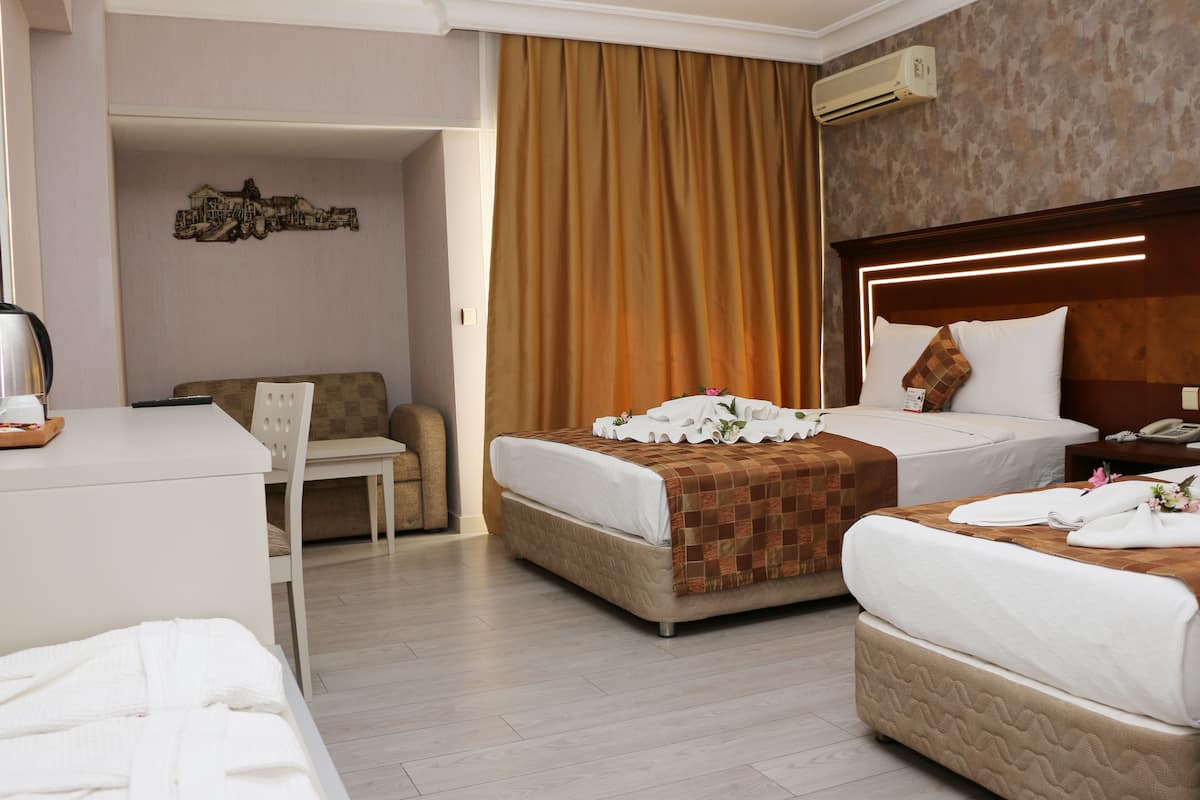 A hotel room with two beds, a desk, and a chair.