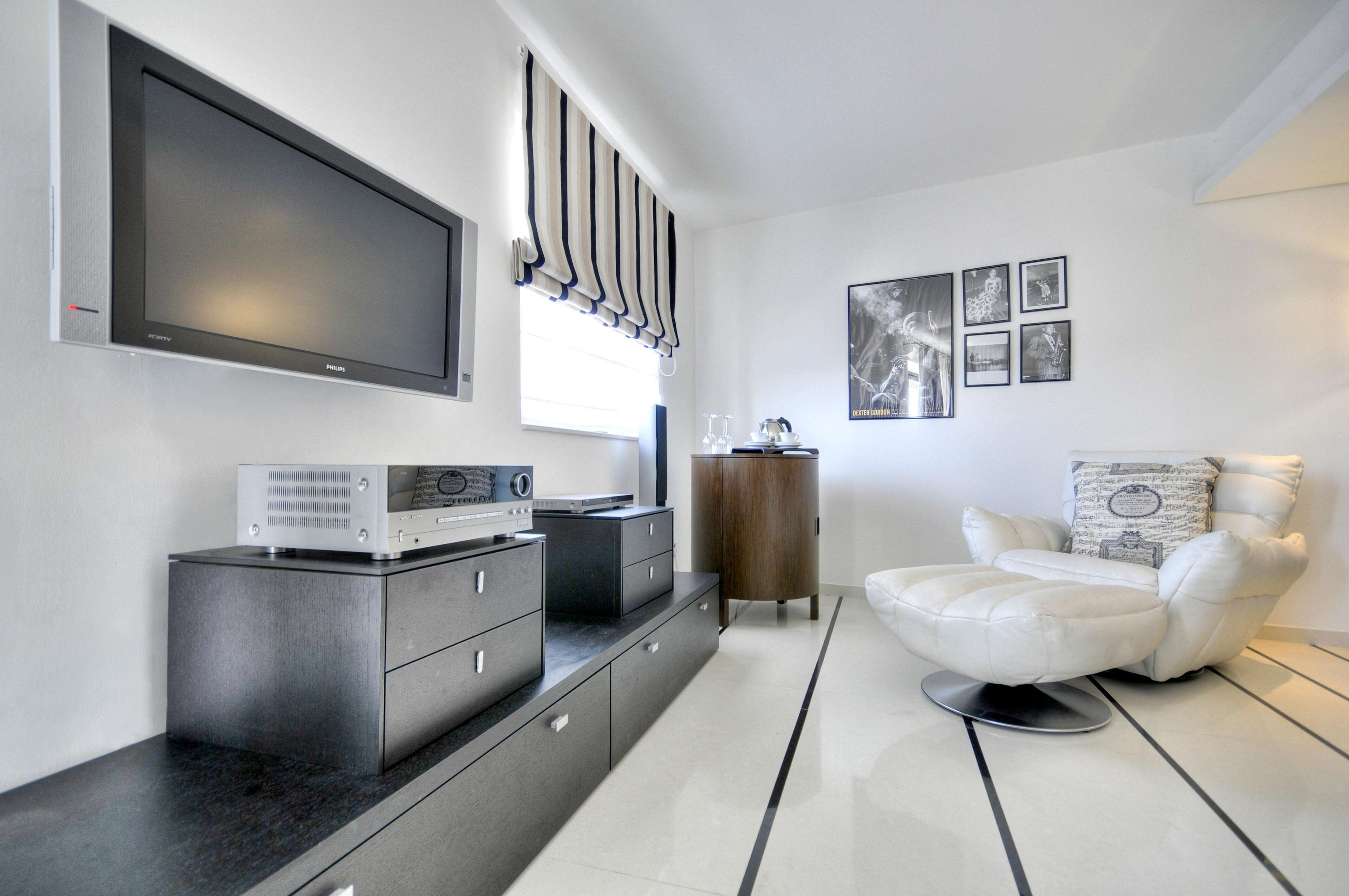 A modern living room with a flat-screen TV, a sound system, a sofa, and a coffee table.