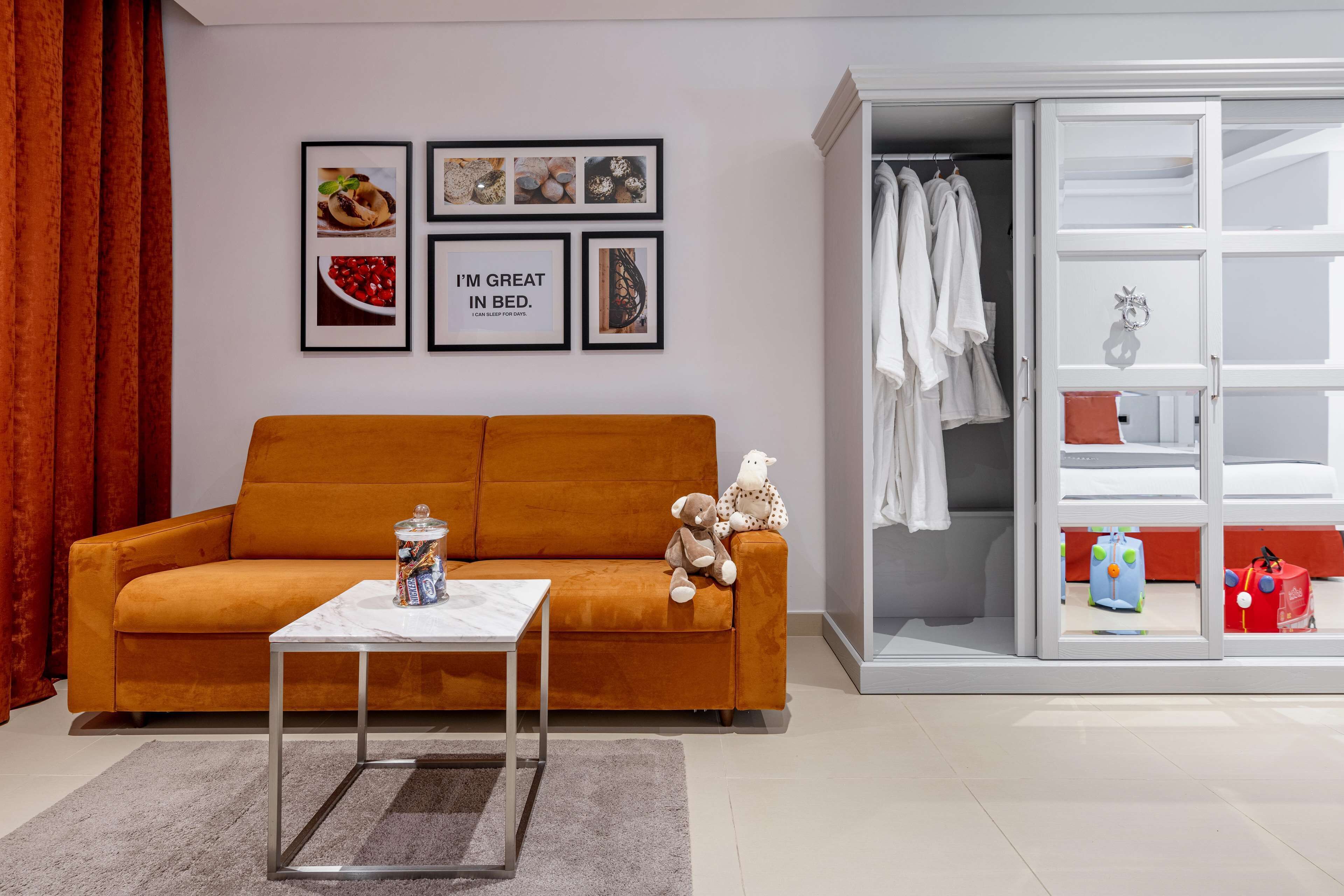 A living room with a sofa, a coffee table, and a wardrobe with a mirror.