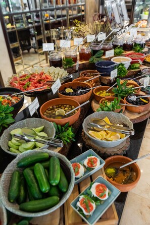 A buffet with various food items and condiments. - Bodrium Hotel & Spa - City Center (Bodrum)