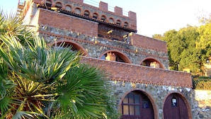 A historic building with stone and brick architecture, featuring arched windows and a balcony. - Ippotur Medieval Resort (Castelnuovo Magra)
