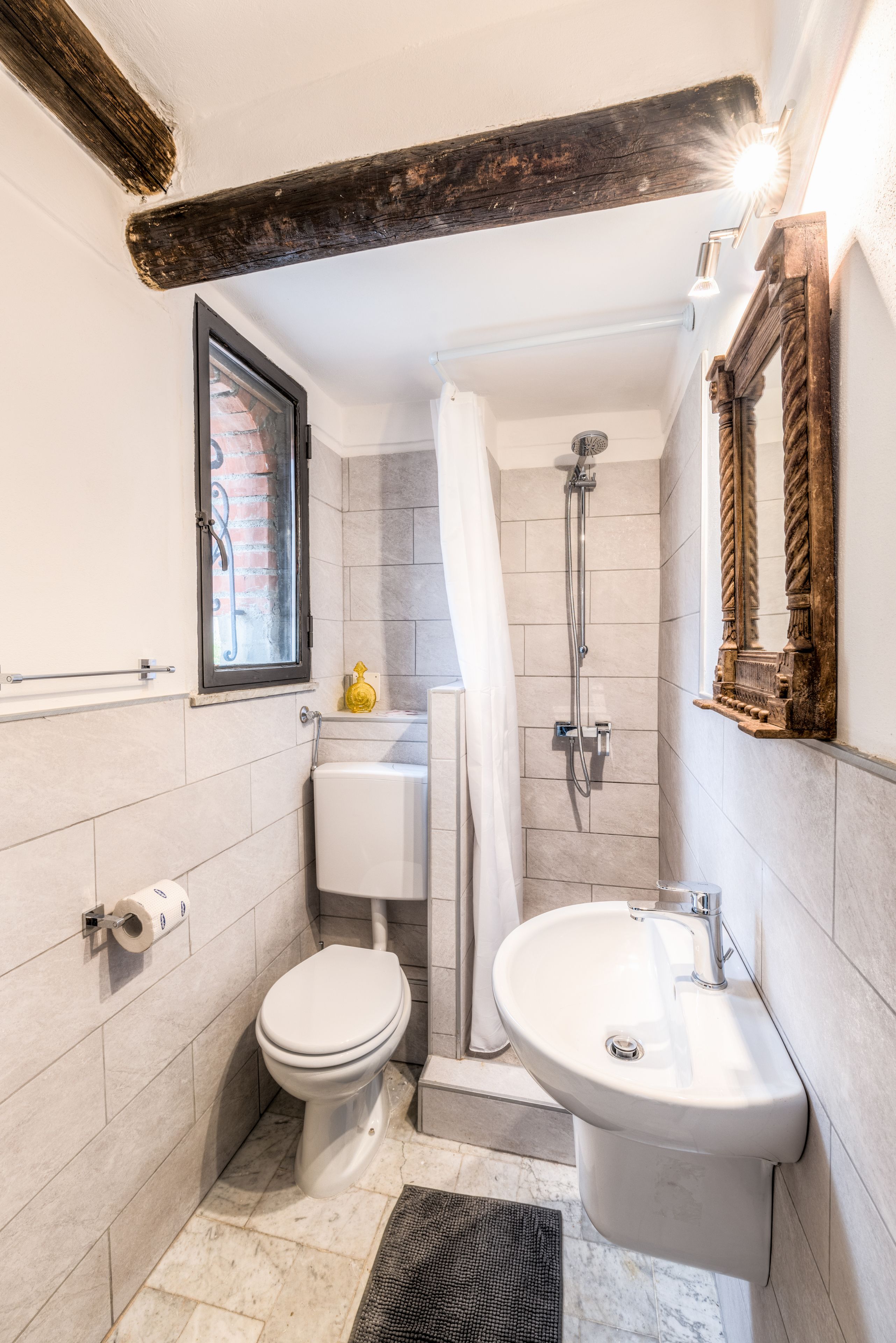 Une petite salle de bain comprenant des toilettes, un lavabo et une douche.