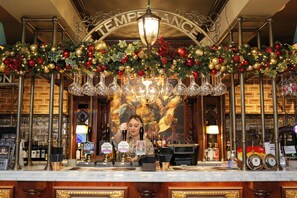 A bar area with a Christmas decoration, a bartender, and a sign reading "TEMPERANCE".