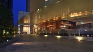 Ein modernes Gebäude mit Glasfassade und gut beleuchtetem Eingang.