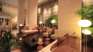 Eine moderne Lobby mit einer Couch, Sesseln, einem Couchtisch und einer Treppe.