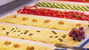 A buffet with various food items including pasta, vegetables, and garnishes.