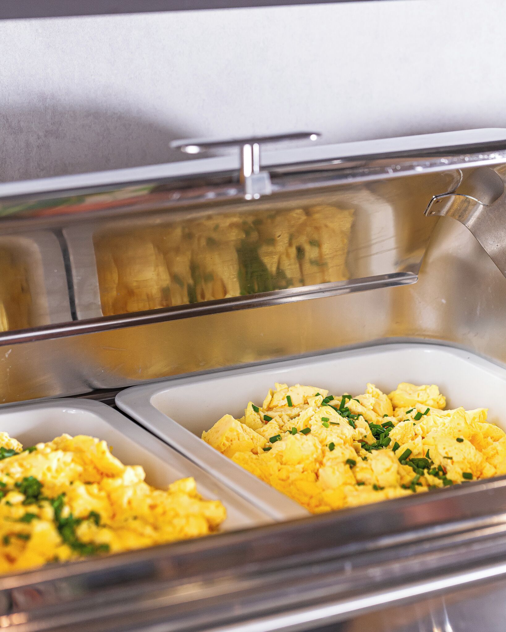 Ein Buffet mit zwei Schüsseln Rührei, garniert mit Schnittlauch.