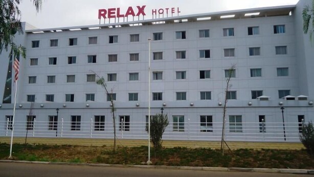 Un edificio de varios pisos con el letrero "RELAX HOTEL" en la parte superior.