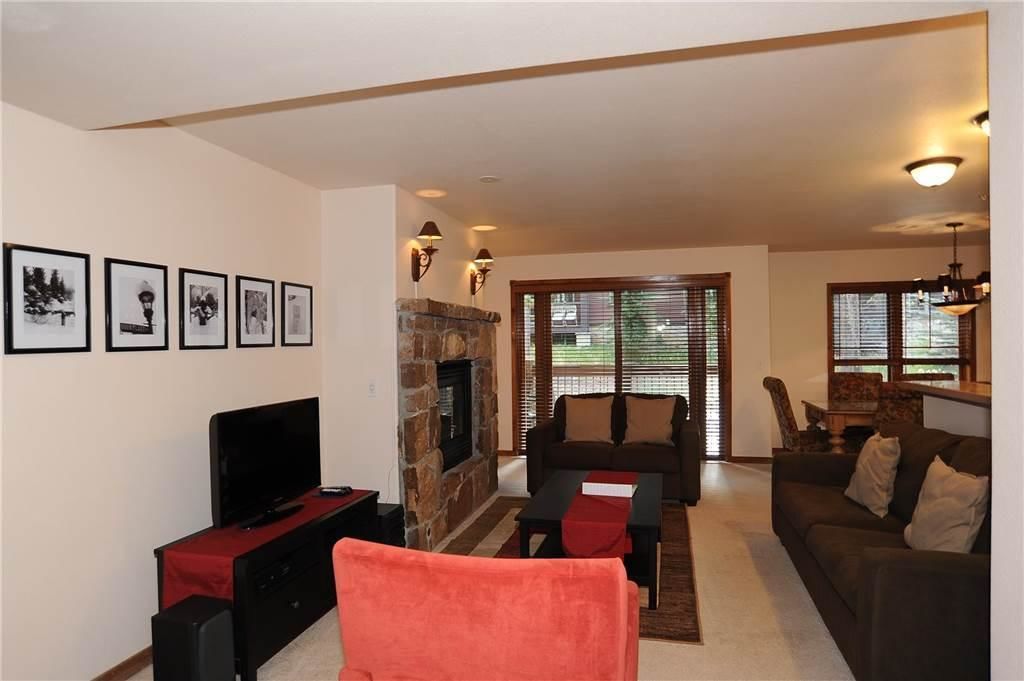 A living room with a fireplace, a television, and a sofa.