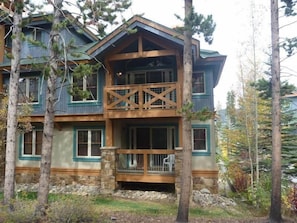 A multi-story log cabin with a stone foundation, wooden balconies, and a porch with a railing. - Los Pinos by Breckenridge Resort Managers (Breckenridge)