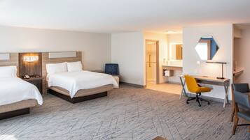 Een hotelkamer met twee bedden, een bureau en een stoel.