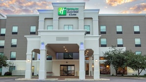 Un bâtiment Holiday Inn Express & Suites doté d’une façade moderne, de grandes fenêtres et d’une entrée accueillante.