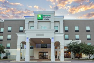A Holiday Inn Express & Suites building with a modern facade, large windows, and a welcoming entrance.