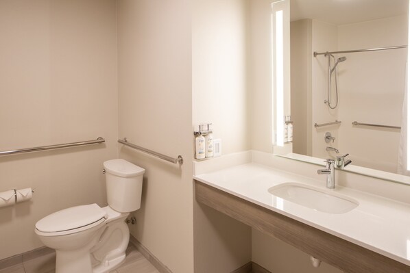 Une salle de bain moderne équipée de toilettes, d’un lavabo, d’une douche et d’un miroir.