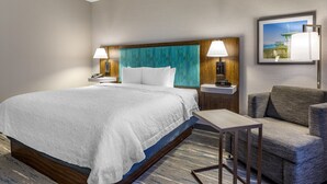 A hotel room with a large bed, two bedside tables, a chair, and a small table. - Hampton Inn Carlsbad-North San Diego County (Carlsbad)