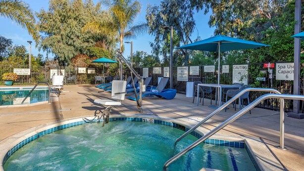 A swimming pool area with lounge chairs, umbrellas, and safety signs. - Hampton Inn Carlsbad-North San Diego County (Carlsbad)