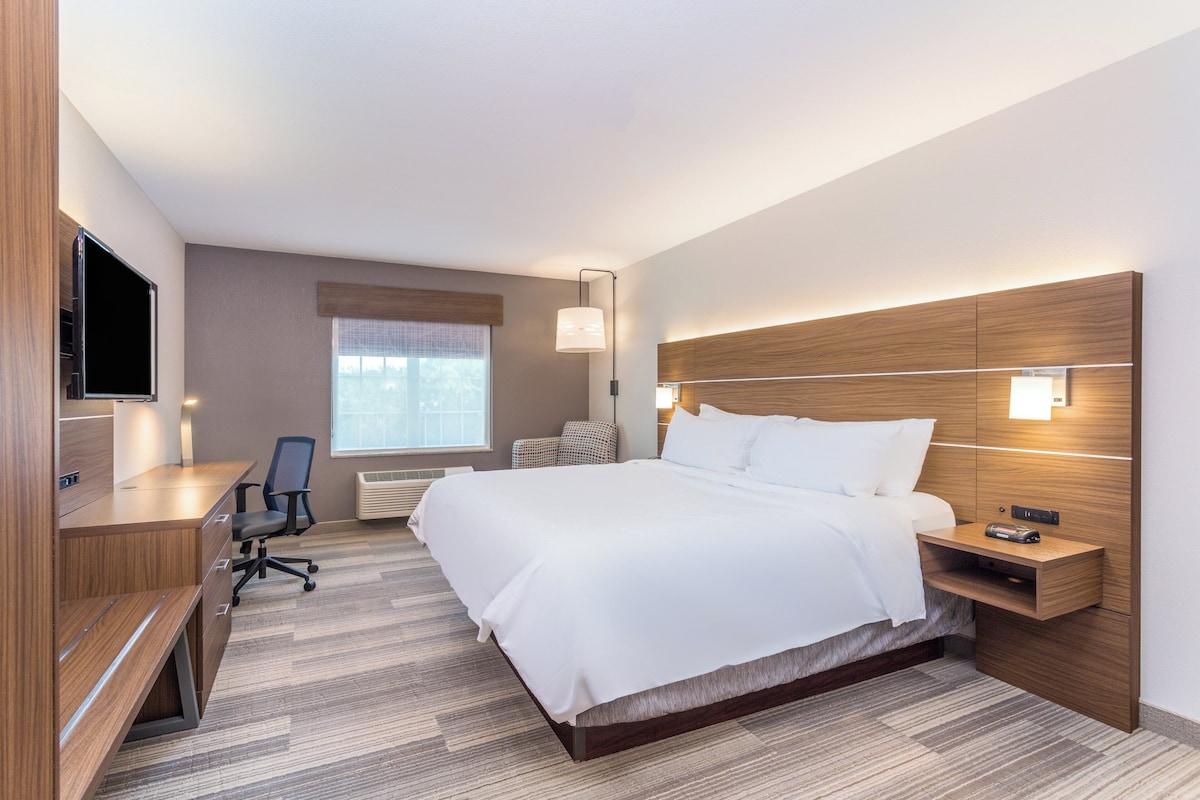 Une chambre d’hôtel équipée d’un lit, d’un bureau, d’une chaise et d’un téléviseur.