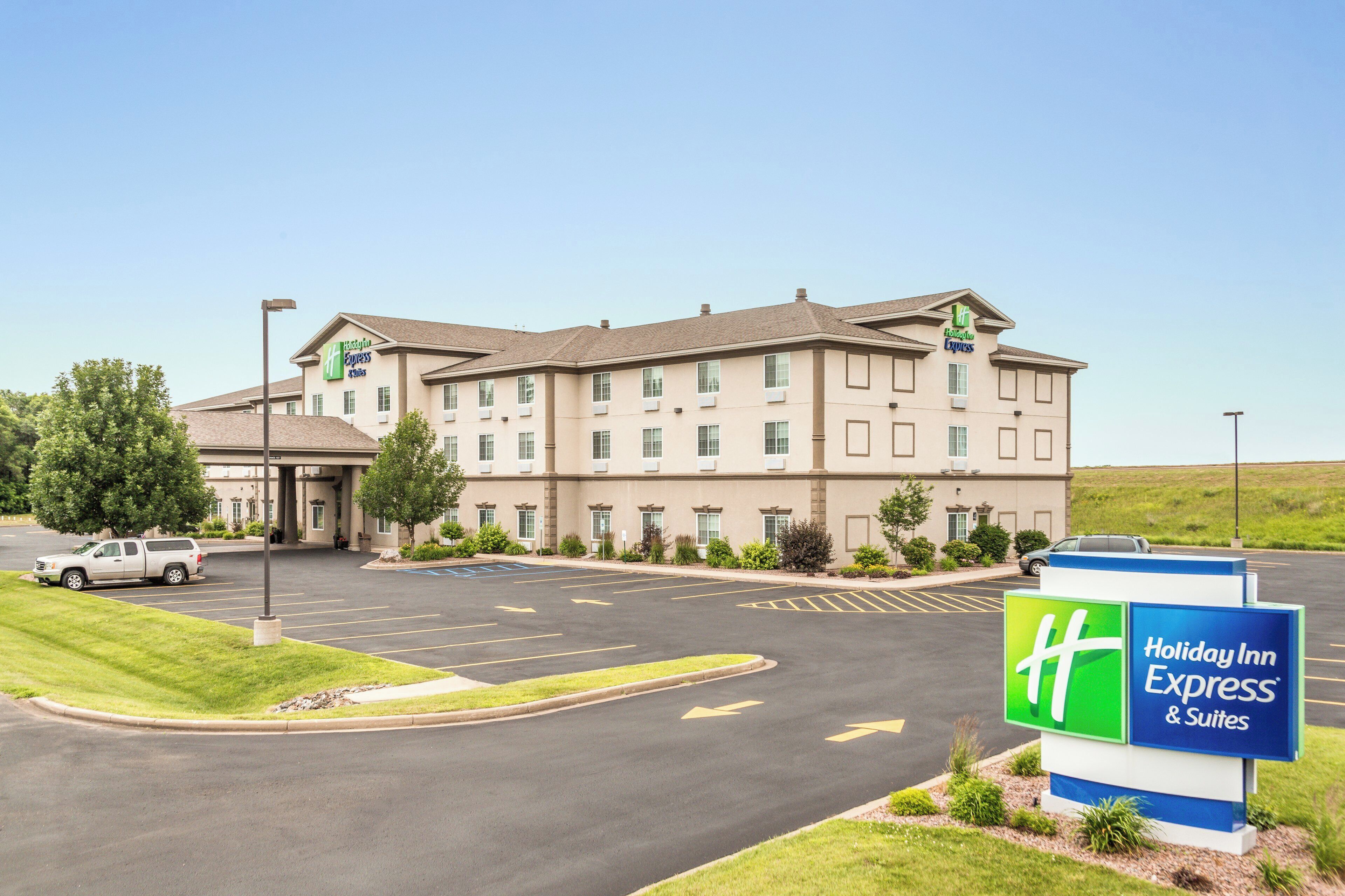Un hotel Holiday Inn Express & Suites con aparcamiento y cielo despejado.