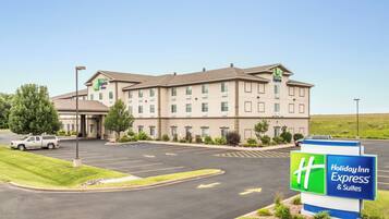 Un hotel Holiday Inn Express & Suites con aparcamiento y cielo despejado.