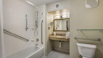 Een badkamer met een bad, douche, toilet en wastafel.