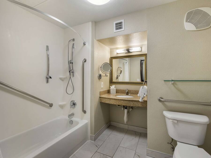 A bathroom with a bathtub, shower, toilet, and sink.