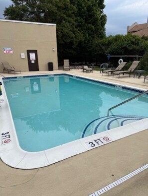 A rectangular swimming pool with a 3 FT depth marker, surrounded by lounge chairs and a small table. - Comfort Inn & Suites Chestertown (Chestertown)