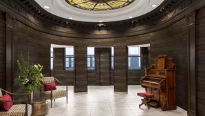 A grand lobby with a piano, seating area, and a large stained glass ceiling. - Homewood Suites by Hilton Nashville-Downtown (Nashville)