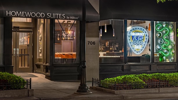 A hotel entrance with a sign for Homewood Suites by Hilton and a bar with a neon sign. - Homewood Suites by Hilton Nashville-Downtown (Nashville)