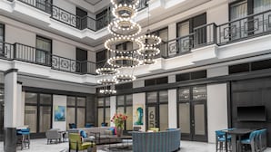A spacious lobby with a central seating area, multiple balconies, and a modern chandelier. - Homewood Suites by Hilton Nashville-Downtown (Nashville)
