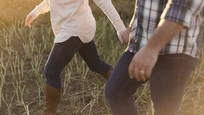 Dos personas caminando por un campo.