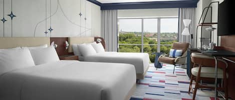 A hotel room with two beds, a desk, a chair, a TV, and a large window with a city view.