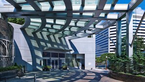 A modern building with a glass facade and a curved roof structure. - Le Meridien Arlington (Arlington)