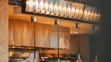A modern kitchen with pendant lighting, a built-in stove, and a hanging light fixture above the counter.