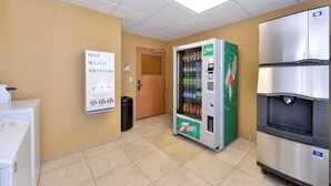 A restroom with a 7Up vending machine, a refrigerator, and a soap and bleach dispenser. - Holiday Inn Laramie by IHG (Laramie)