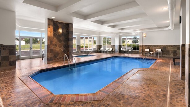 An indoor swimming pool with a tiled floor and a clear blue pool. - Holiday Inn Laramie by IHG (Laramie)