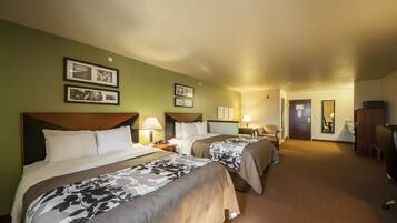 A hotel room with two beds, a desk, a chair, a TV, and framed pictures on the wall.