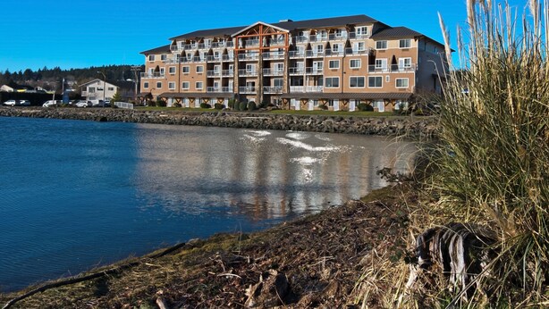 Un hotel a più piani con balconi, affacciato su un corso d'acqua.