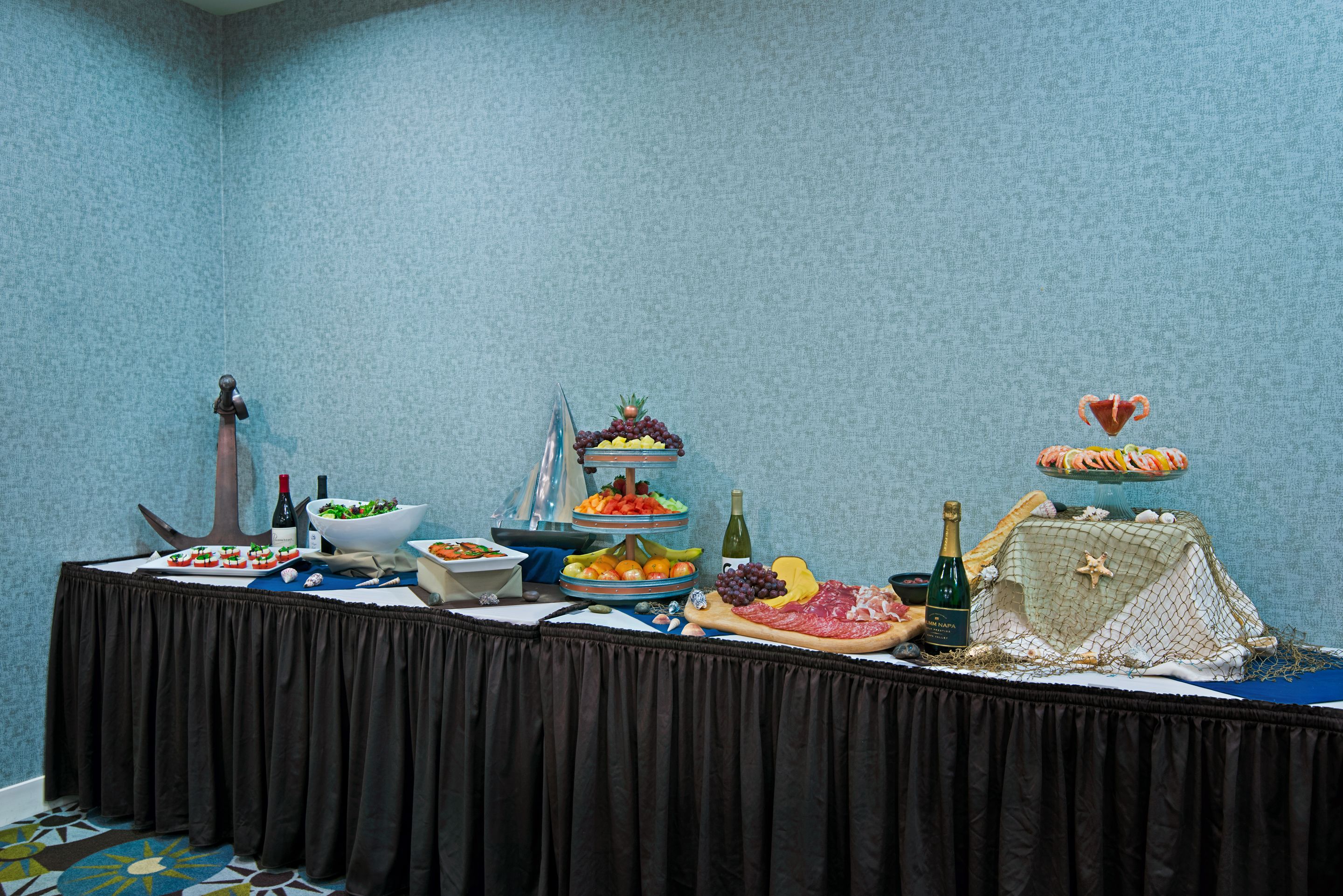 A buffet table with various food items and a decorative centerpiece.
