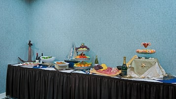 A buffet table with various food items and a decorative centerpiece.