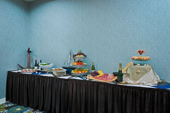 A buffet table with various food items and a decorative centerpiece. - Oxford Suites Silverdale (Silverdale)