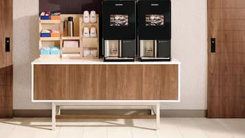 Una estación de café moderna con dos máquinas de café, una cafetera y varios recipientes para café sobre una encimera de madera.