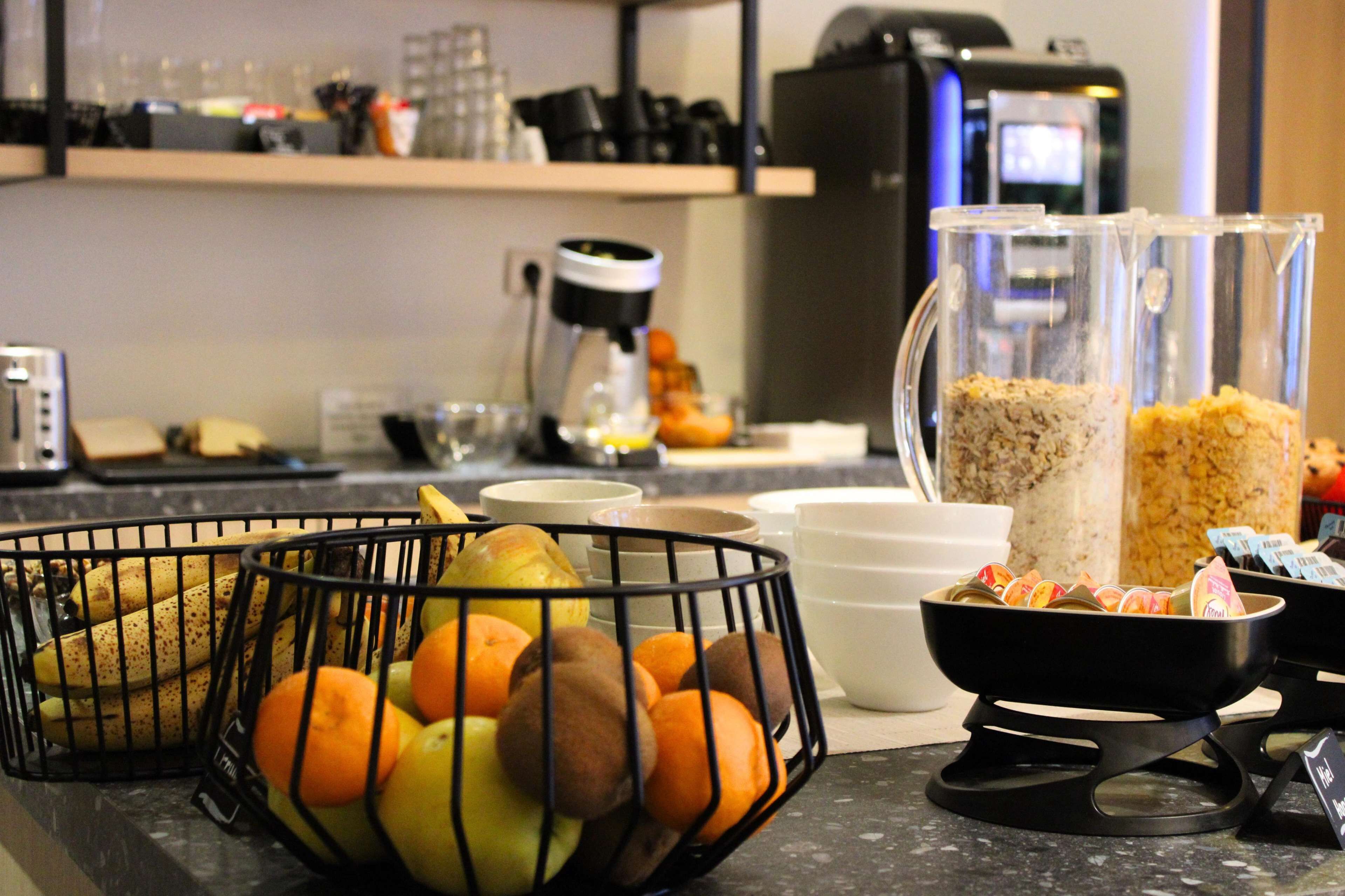 Een aanrecht met een fruitmand, een koffieapparaat en een blender.