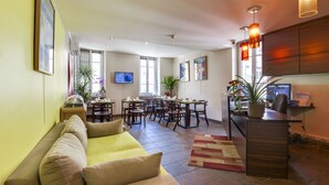 Una sala moderna con sofá, comedor y cocina al fondo.