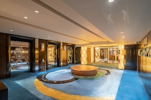 Relax in the stylish lobby with a central seating area and geometric patterns on the walls.