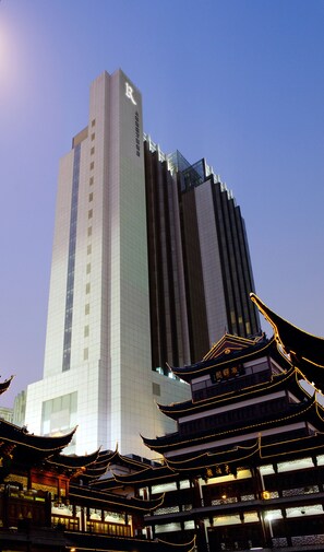 A modern building with a traditional Chinese architectural structure in front.