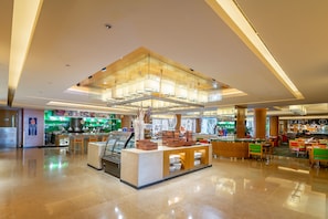 A spacious lobby with a central counter, seating area, and a large glass wall.