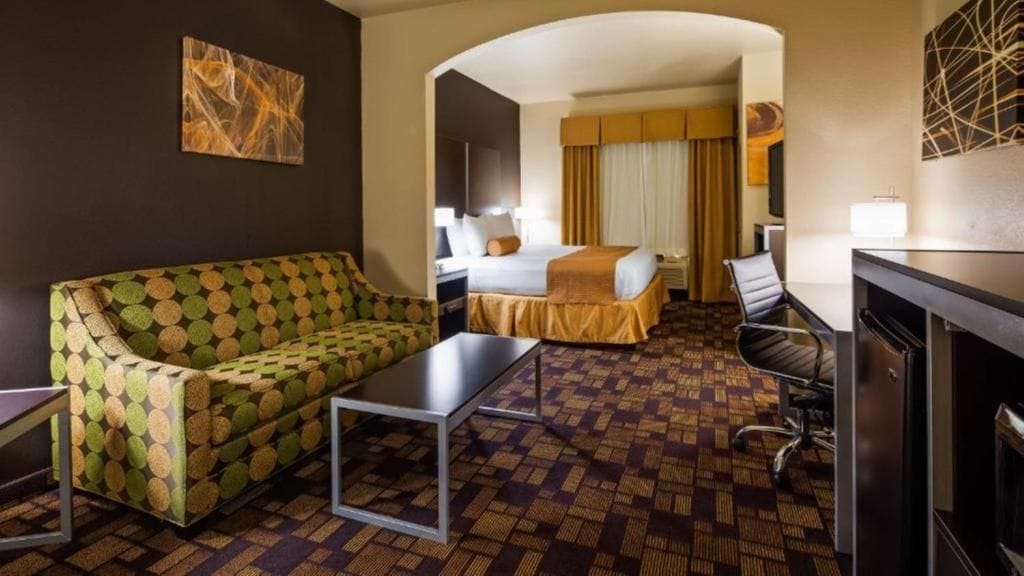 Une chambre d’hôtel avec un canapé, un lit, un bureau et une télévision.