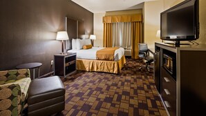 A hotel room with a bed, a desk, a television, and a seating area. - Best Western Windsor Pointe Hotel & Suites-Frost Bank Center (San Antonio)