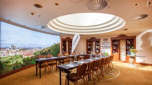 Une salle de conférence offrant une vue panoramique sur la ville, une grande table entourée de chaises et une banderole sur laquelle on peut lire « Lindner ».